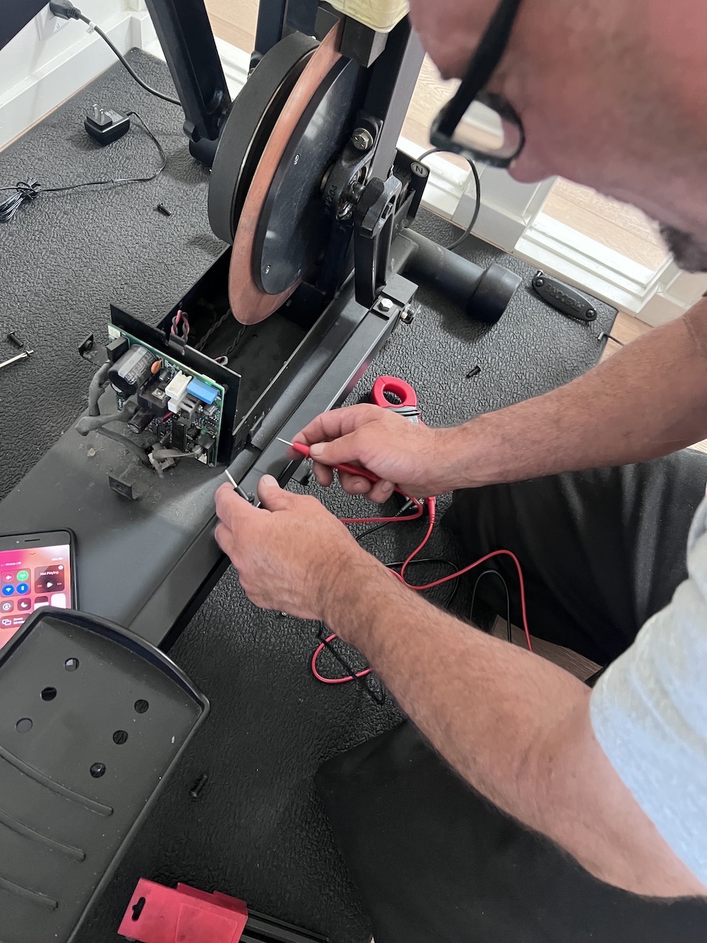 Professional gym equipment repair technician diagnosing fitness equipment